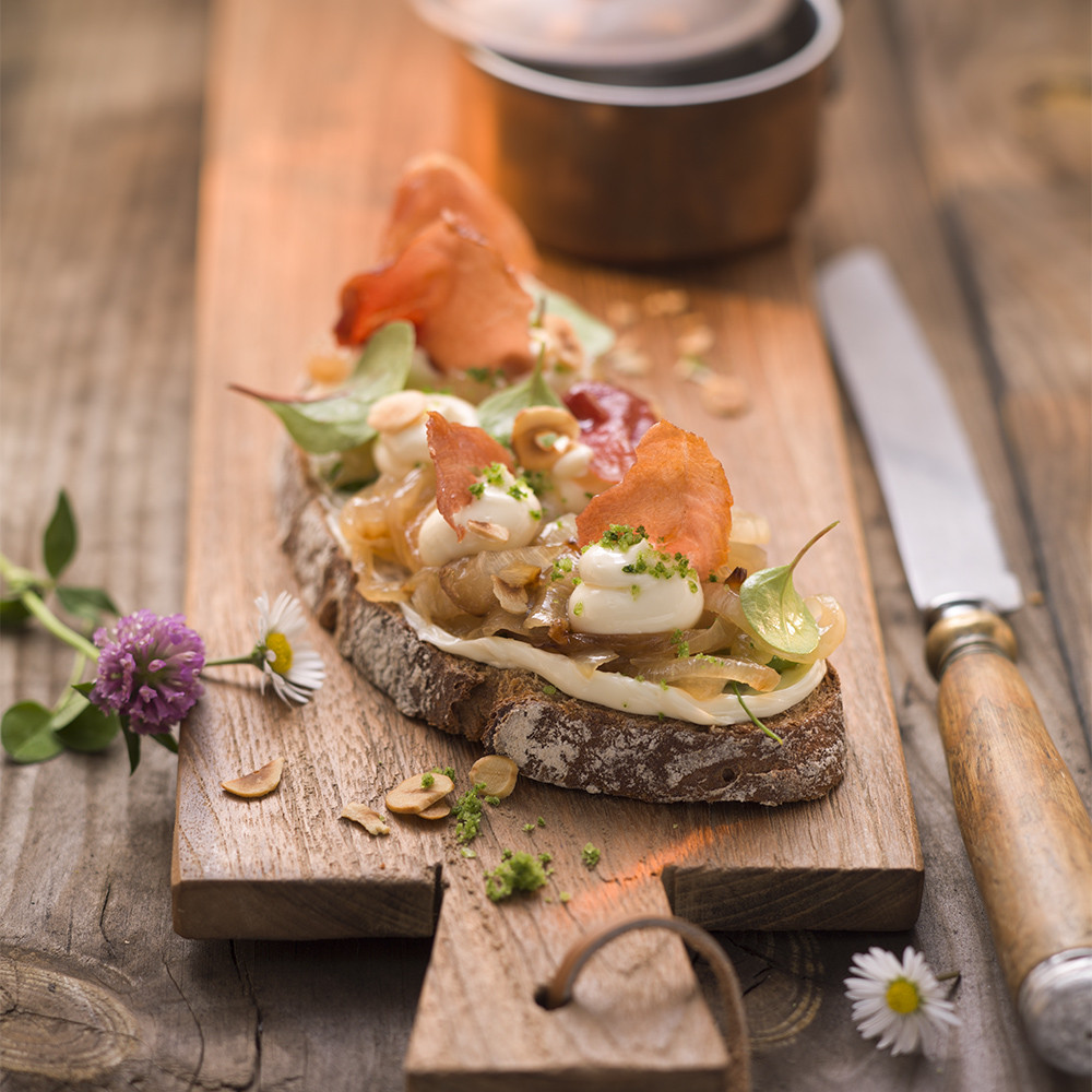 Bauernbrot mit geschmolzenen Zwiebeln, Schinkenchips und Petersiliensalz